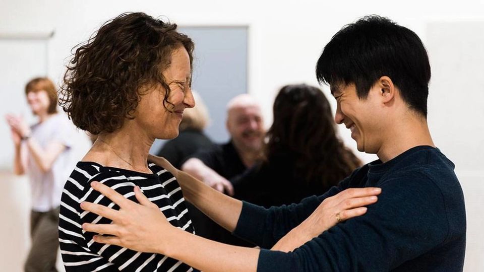 Two people embracing in an actor training workshop