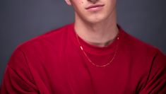 Headshot of Calum, waist up, a white male in a red mesh top