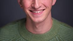 Headshot of Calum, white male, smiling in a green jumper